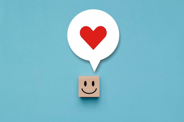 Cubo de madeira com cara feliz com um pensamento feliz em sua cabeça bloco de madeira com uma cara de sorriso de emoção e amor em pensamentos