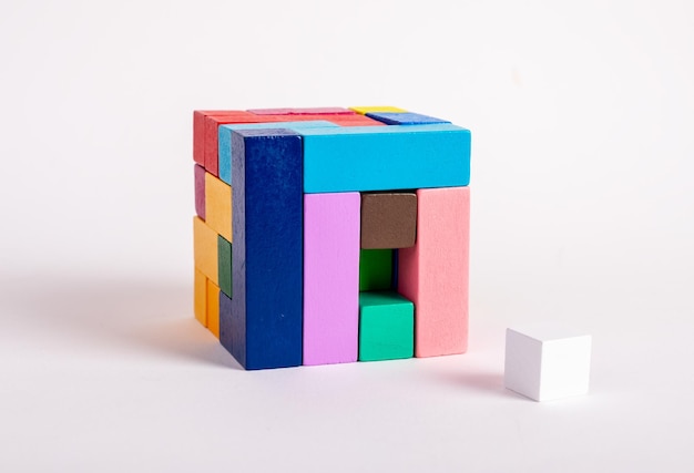 Cubo de madeira de blocos multicoloridos com um elemento faltando Conceito de última etapa da construção Jogo infantil para o desenvolvimento do pensamento lógico