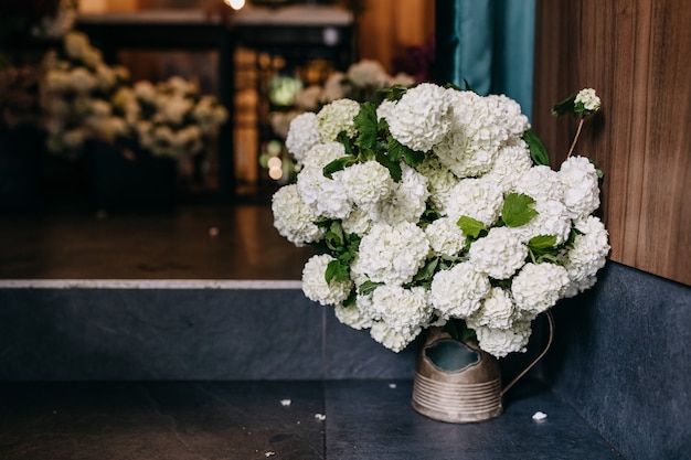 Cubo con flores de hortensias en una florería