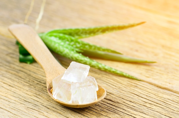 Cubo de gel de aloe vera en cuchara de madera.