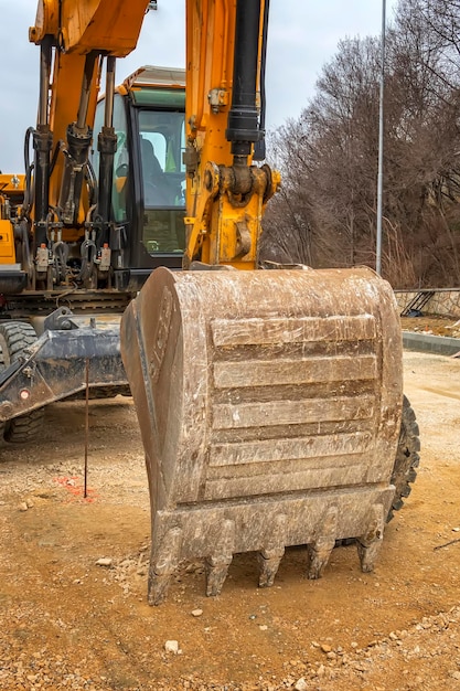 Cubo grande y manipulador del brazo de la excavadora con mangueras hidráulicas y cilindro en acción Cerrar