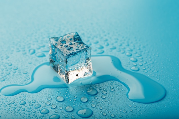 Foto cubo de hielo con gotas de agua. el hielo se está derritiendo.