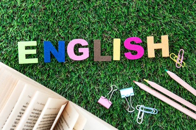 Foto cubo inglés colorido de la palabra en la yarda de la hierba verde, concepto del aprendizaje de idiomas ingleses