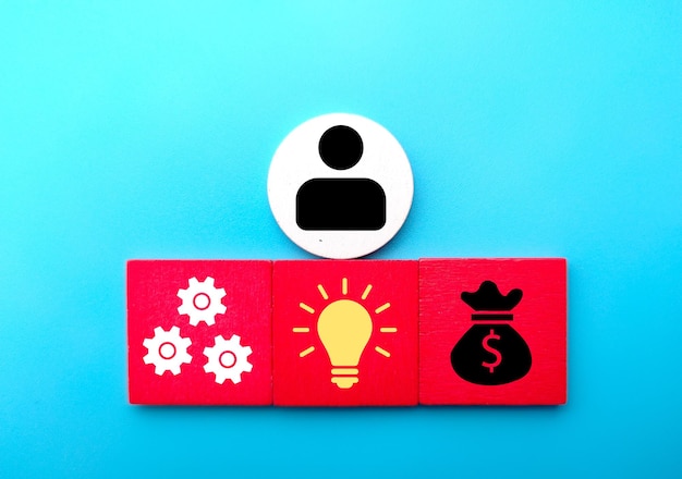 Cubo de madera coloreado con iconos de ideas de gestión y dinero