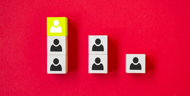 Foto el cubo de madera con el icono de la persona se destaca entre la multitud sobre fondo rojo. opinión disidente, puntos de vista divergentes y conceptos diferentes