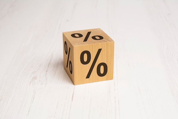 Cubo de madera con signo de porcentaje en el espacio de fondo blanco para texto