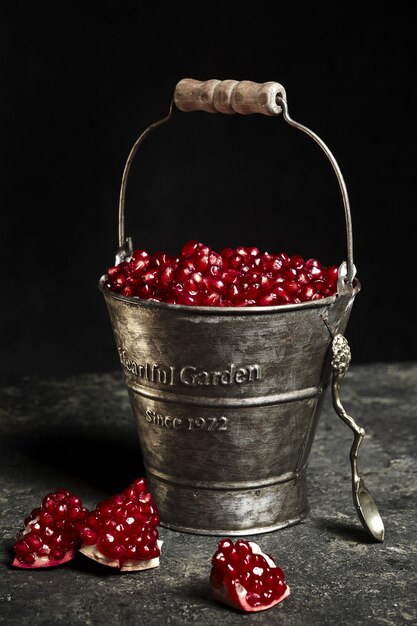 Cubo de metal con frutos de granada.