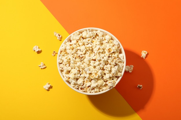 Cubo con palomitas de maíz en dos tonos de fondo