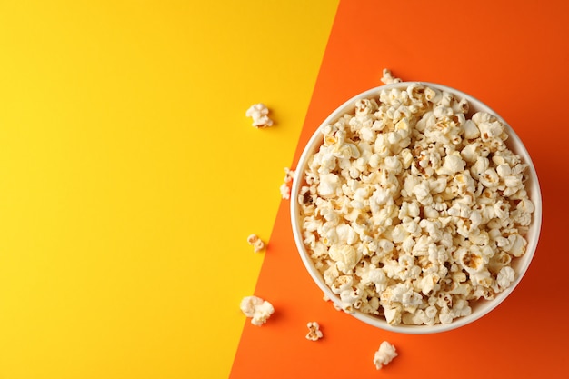 Cubo con palomitas de maíz en dos tonos de fondo