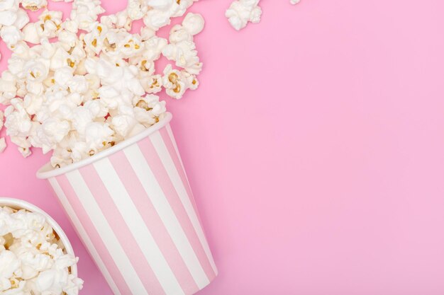 Cubo de palomitas de maíz sobre fondo rosa Fondo de película o televisión Vista superior Espacio para copiar