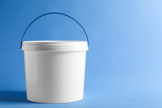 Un cubo de plástico con tapa sobre un fondo azul claro Espacio para el texto