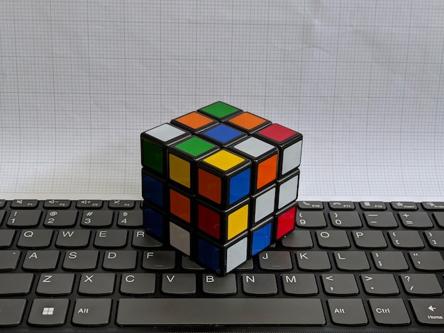 Un cubo de rubik se sienta en un teclado