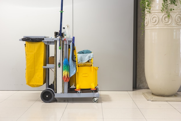 Cubo de trapeador amarillo y conjunto de equipos de limpieza en el aeropuerto