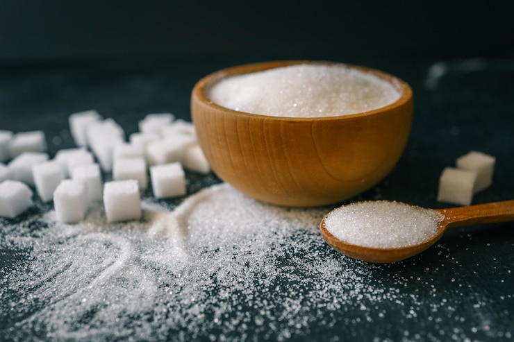Foto cubos de azúcar cristalino blanco en una cuchara de madera