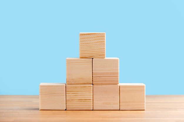 Foto cubos de bloques de madera en blanco sobre un fondo azul para su espacio libre de texto para la plantilla de concepto de negocio