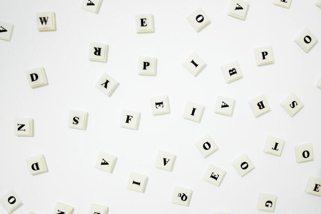 Cubos brancos com letras espalhadas aleatoriamente em uma vista superior de fundo branco