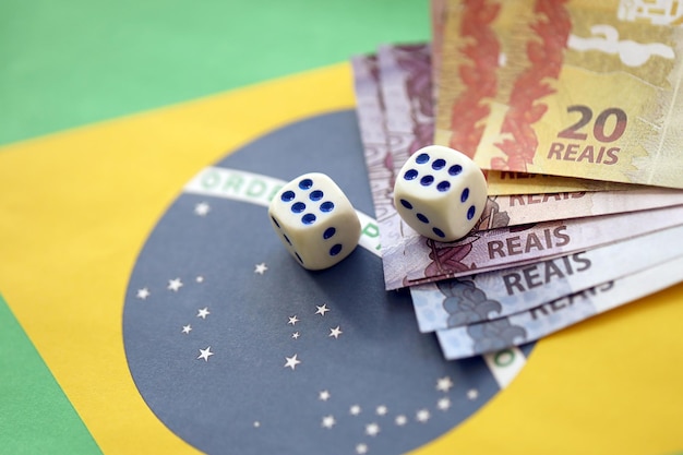 Foto cubos de dados con billetes de dinero brasileño en la bandera de la república de brasil concepto de suerte y juego en brasil