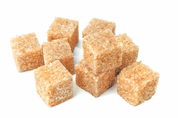 Cubos de açúcar de cana marrom isolados no recorte branco.