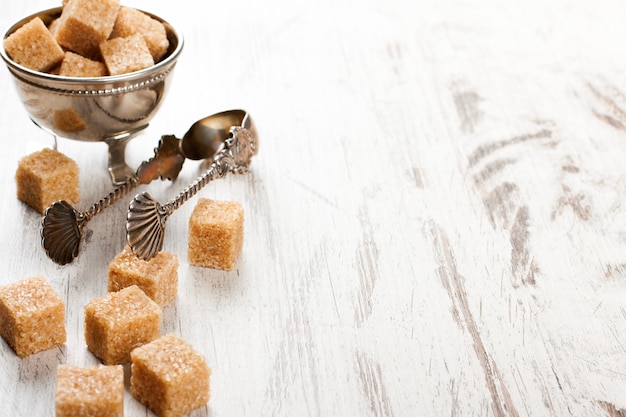 Cubos de açúcar mascavo e pinças de metal sugat