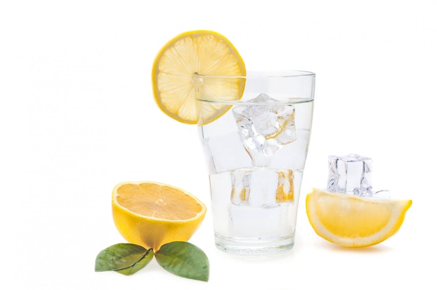 Cubos de água, limão e gelo em um copo. Fatias de limão e linho ao lado de um copo. Isolado.