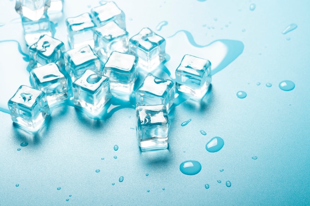 Cubos de gelo com água sobre um fundo azul. Conceito de gelo para bebidas.