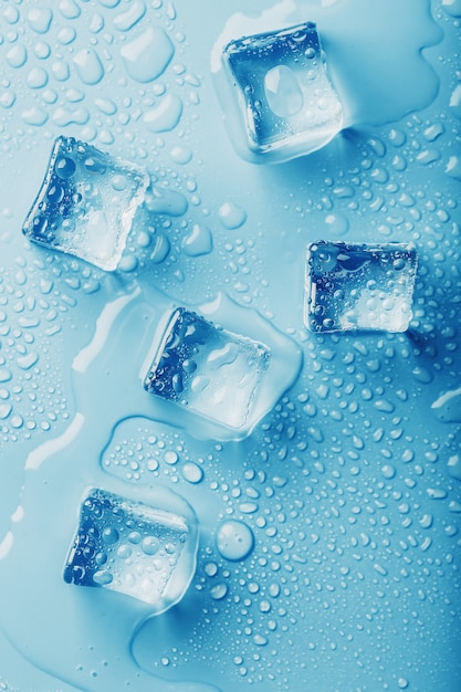 Cubos de gelo com gotas de água derretida em um azul