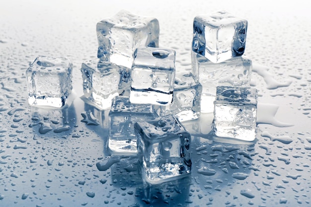 Cubos de gelo derretendo no fundo cinza close-up