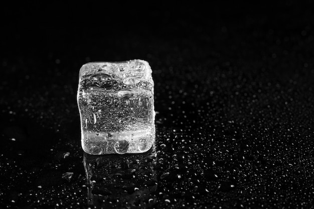 Cubos de gelo na superfície preta da mesa.