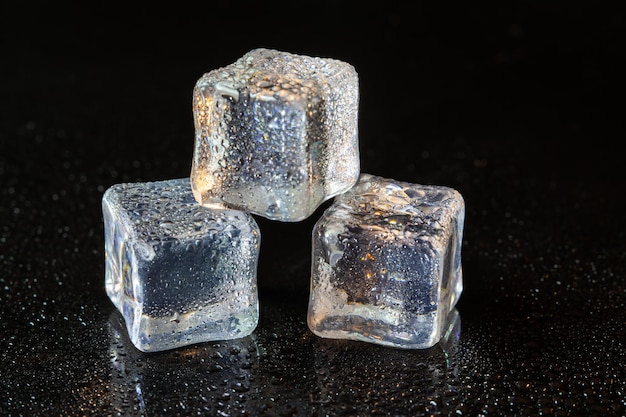 Cubos de gelo no fundo da mesa preta