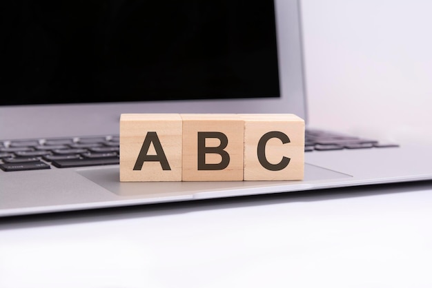 Cubos de madeira ABC com letras em um teclado de laptop