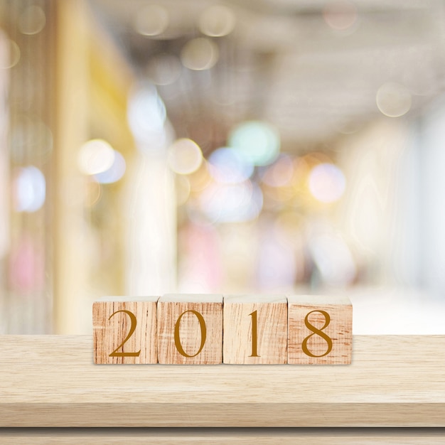 Cubos de madeira com 2018 na mesa sobre fundo bokeh borrão com espaço de cópia para texto