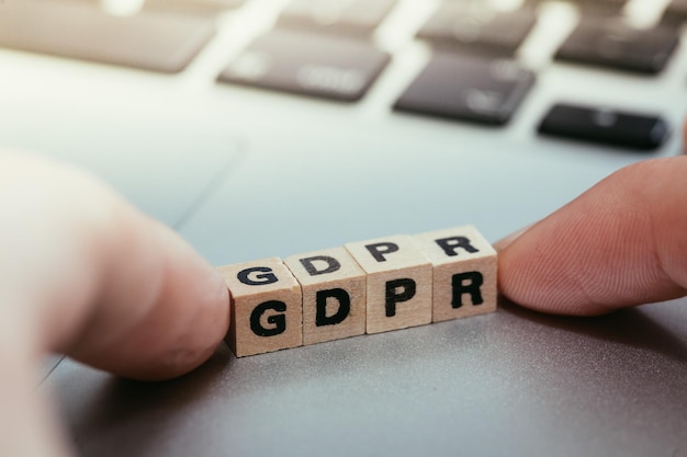 Cubos de madeira com as letras GDPR para Regulamento Geral de Proteção de Dados estão em um laptop