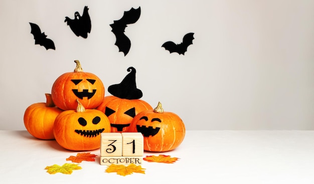 Cubos de madeira com os números 31 de outubro e abóboras na mesa com fundo branco conceito de celebração de Halloween