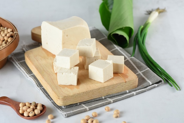 Cubos de tofu vegetariano orgânico cru em fundo de madeira