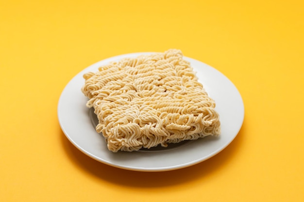 Cubos de fideos frescos secos en un plato blanco