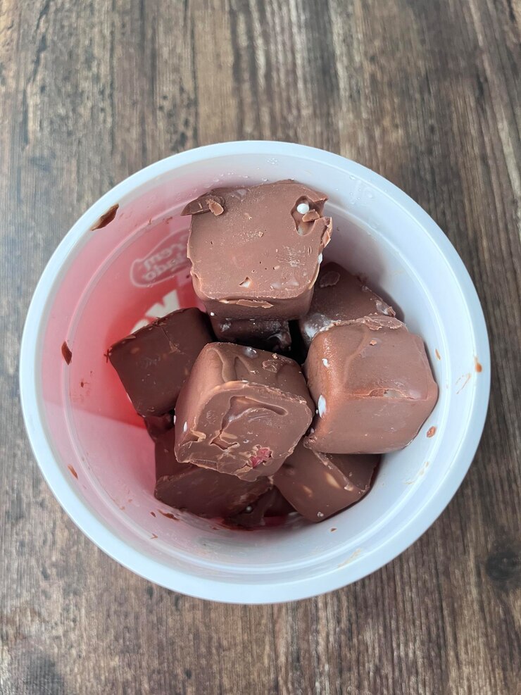 Cubos de helado de chocolate en una taza sobre una mesa de madera