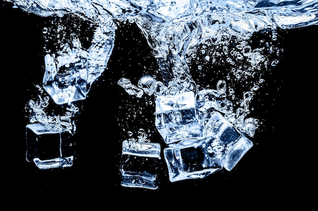 Cubos de hielo en agua en fondo oscuro del estudio El concepto de frescura con frescura de los cubos de hielo