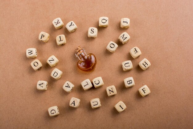 Cubos de letras hechos de madera alrededor de una botella