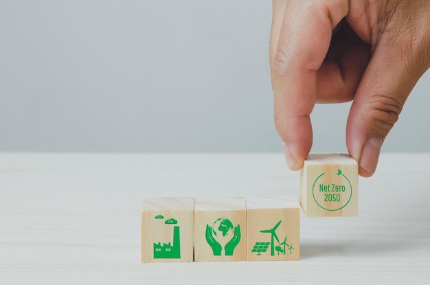 Cubos de madera con cero neto y fondo de símbolo de icono de fábrica verde neutro en carbono y espacio de copia