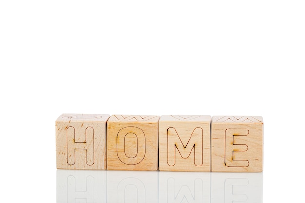 Cubos de madera con letras a casa sobre un fondo blanco.