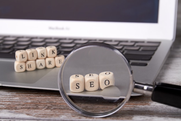 Foto cubos de madera con letras en la computadora portátil y lupa