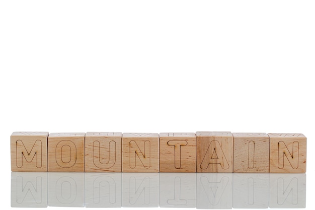 Cubos de madera con letras montaña sobre un fondo blanco.