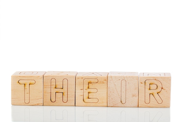 Cubos de madera con letras sobre un fondo blanco.