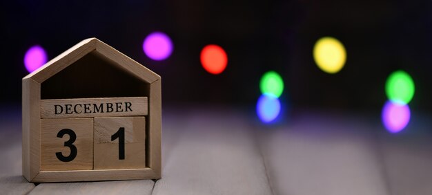 cubos de madera con los números 31 de diciembre y luces bokeh