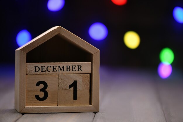 cubos de madera con los números 31 de diciembre y luces bokeh