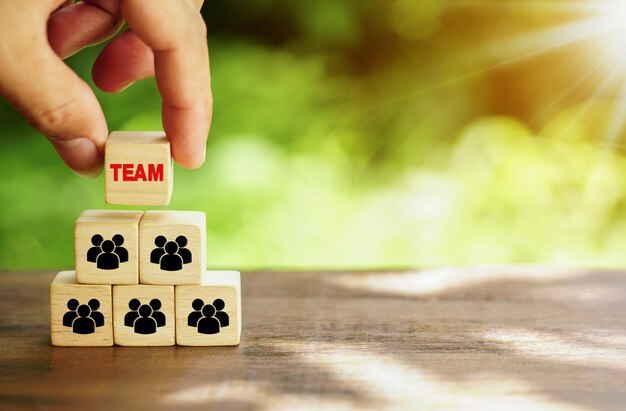 cubos de madera que muestran un equipo y la palabra EQUIPO en la pirámide superior cubos de madera trabajo en equipo