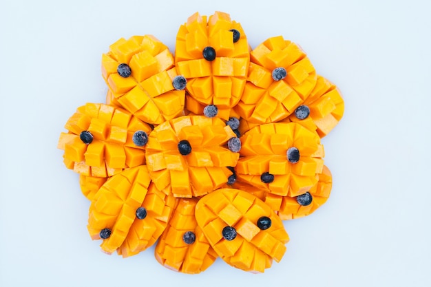 Cubos de mango amarillo maduro con arándanos