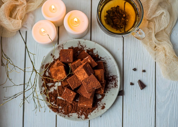 Los cubos de soufflé hechos a mano cubiertos con cacao en polvo yacen en un plato