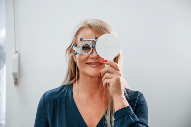 Cubrir el ojo Mujer probando su vista usando anteojos especiales