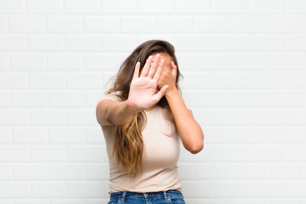 Foto cubrirse la cara con la mano y poner la otra mano al frente para detener la cámara, rechazar fotos o imágenes